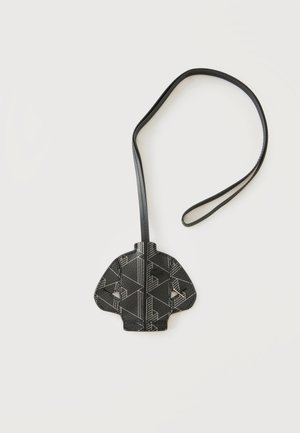 Etiqueta de equipaje negra con estampado geométrico y correa larga, con forma de chaqueta, colocada sobre un fondo blanco liso.