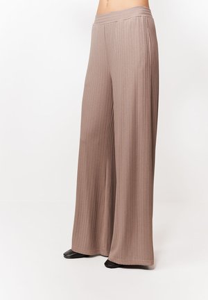 Spodnie z wysokim stanem i szerokimi nogawkami wykonane z prążkowanego dzianiny w kolorze taupe, noszone z czarnymi butami, przedstawione od połowy tułowia do stóp na białym tle.