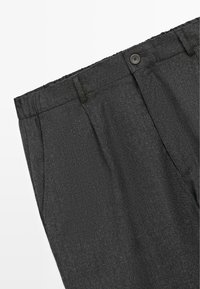 Tmavě šedé kalhoty s texturovanou tkaninou, s knoflíkovým zapínáním, skladbami a bočními kapsami. Jednoduchý design s rovným střihem.