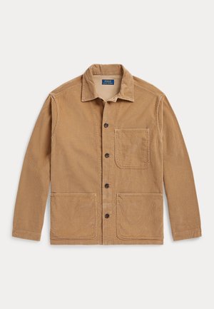 Veste en velours côtelé marron clair avec col, quatre boutons foncés, une poche poitrine et deux poches avant inférieures, posée à plat sur un fond blanc.