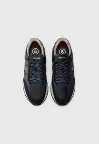 Adidași bleumarin, cu un mix de suede și piele, vârful rotund, design cu șireturi și tălpi marcate cu accente roșii.