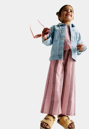 Denimjakke, pinkstribede viddebukser og beige sandaler. Outfittet har bløde teksturer og afslappede designelementer.