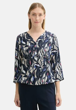 Chemisier fluide bleu marine et crème avec des motifs floraux abstraits. Doté d'un décolleté en V et de manches trois-quarts. Tissu doux et texturé.