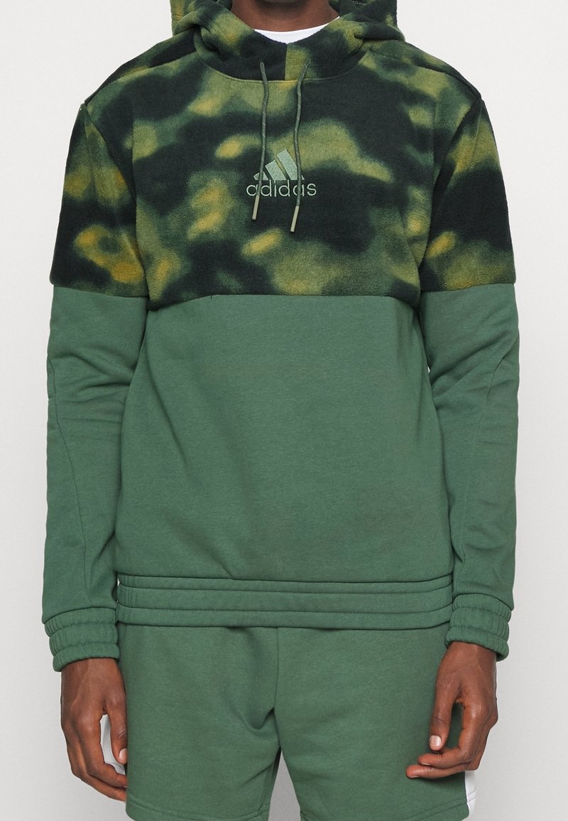 Felpa verde con cappuccio, caratterizzata da una parte superiore con motivo camouflage, realizzata in morbido pile, con una sezione inferiore di un colore solido e cappuccio con cordino.