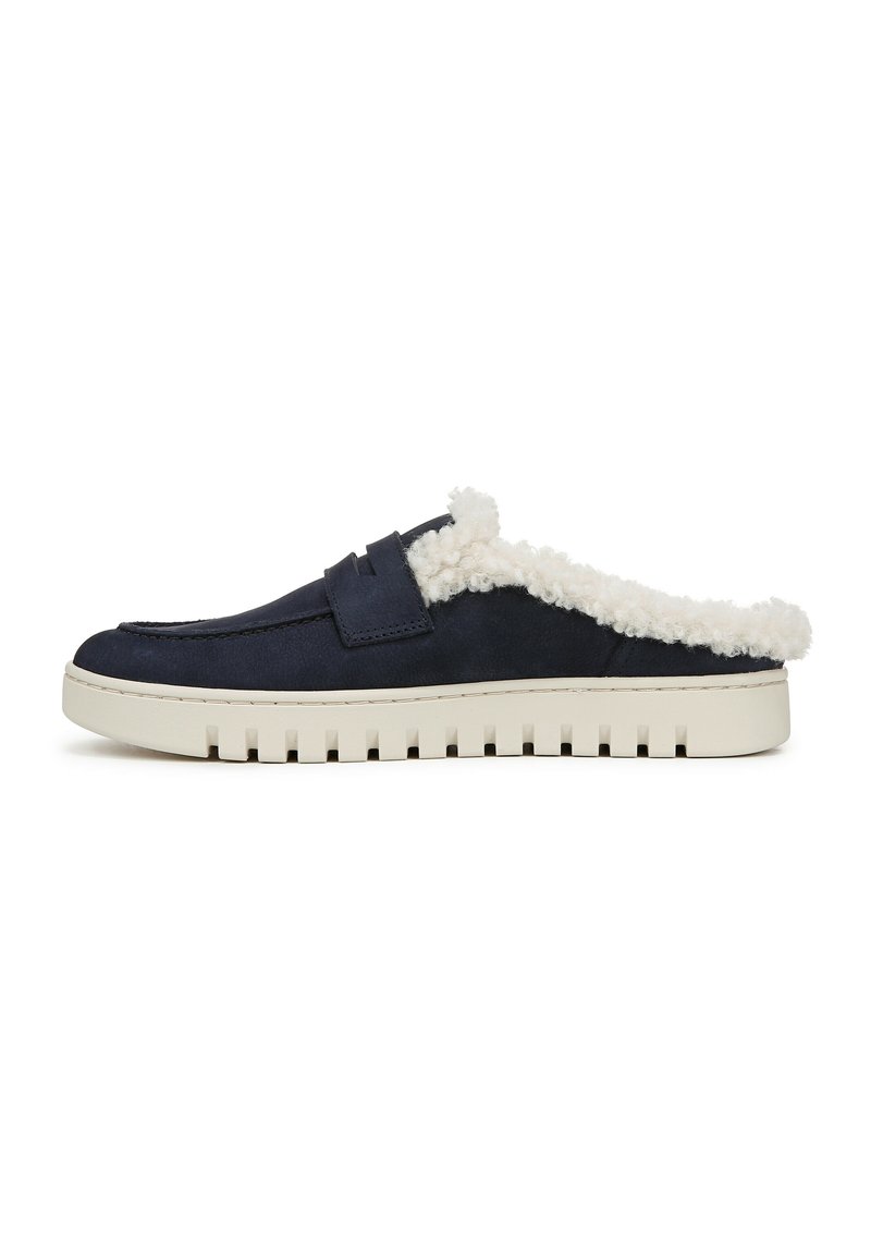 Scarpe slip-on in suede blu navy con una morbida fodera bianca, dotate di una suola piatta in gomma crema e scanalature testurizzate per una migliore aderenza.