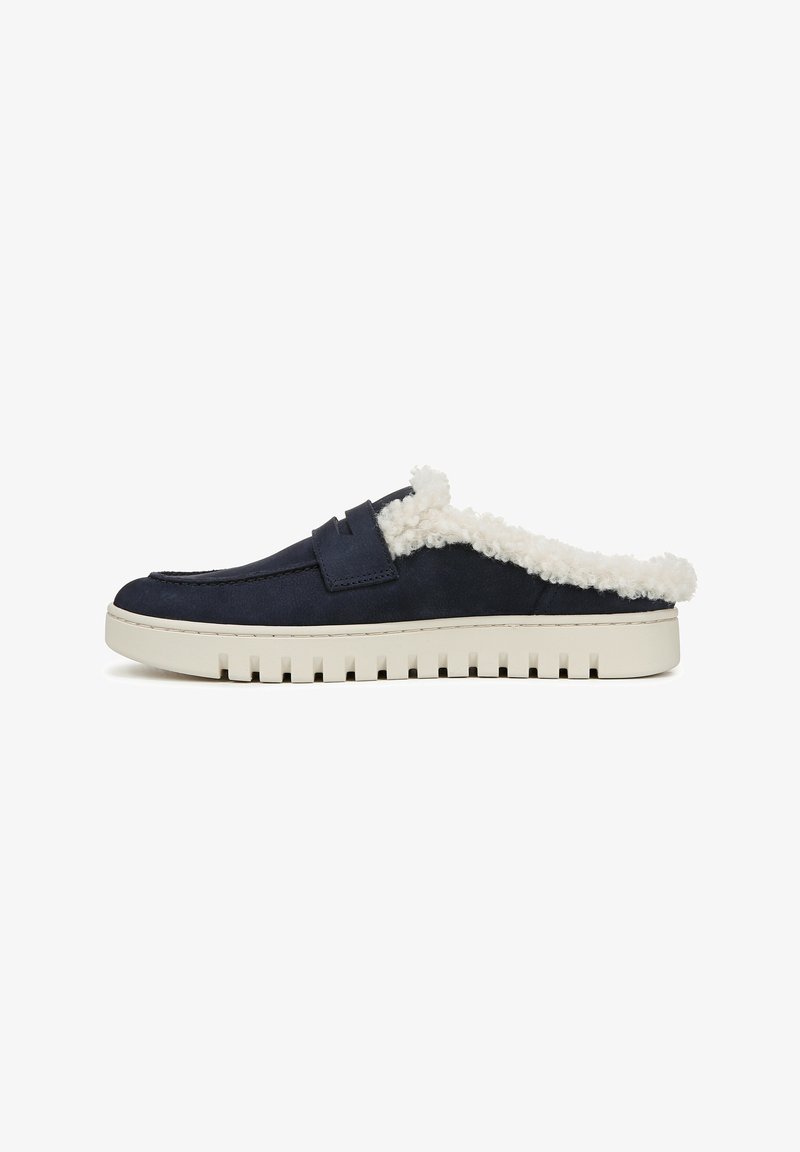 Chaussures en suède bleu marine à enfiler, dotées d'une doublure blanche duveteuse, avec une semelle en caoutchouc crème plate et des rainures texturées pour une meilleure adhérence.