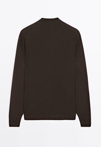 Maglione lungo a maniche, di colore marrone, realizzato in maglia con colletto rotondo. Presenta polsi a coste e un orlo dritto, realizzato in un tessuto morbido e testurizzato.