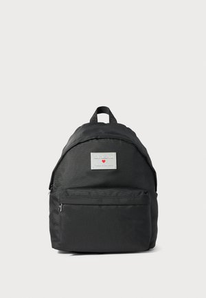 Czarny plecak z kieszenią na zamek z przodu oraz metalową tabliczką z logo "Love Moschino Made with love" i małym czerwonym sercem.