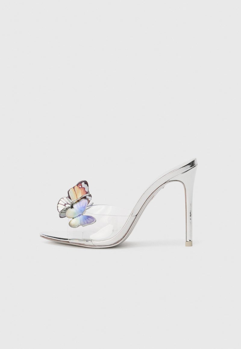 Sandal cu toc înalt transparent, cu un accent metalic argintiu și un detaliu colorat de fluture pe curea, punând în evidență texturi netede.