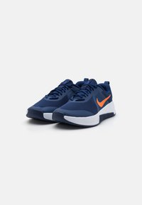 Scarpe da ginnastica blu navy con tomaia in rete, suola bianca e dettagli arancioni. Caratterizzate da lacci e un design testurizzato per una migliore presa.