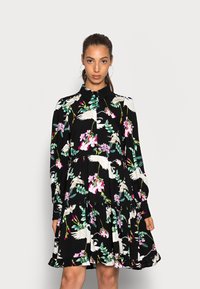 Vestido preto com estampado floral apresentando gruas e orquídeas, mangas compridas e saia em camadas. Detalhes de gola e botões realçam o design.