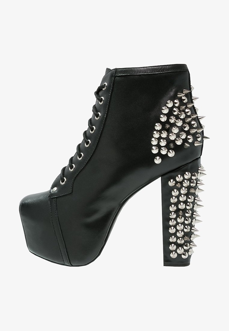 Black leather ankle boot with a platform sole, featuring silver spikes on the heel and side. Laced closure with metal eyelets. High heel design.