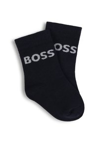 Chaussettes en coton bleu marine avec une texture côtelée, comportant le logo "BOSS" imprimé en blanc sur le côté. Conçues avec une coupe de longueur mi-mollet.