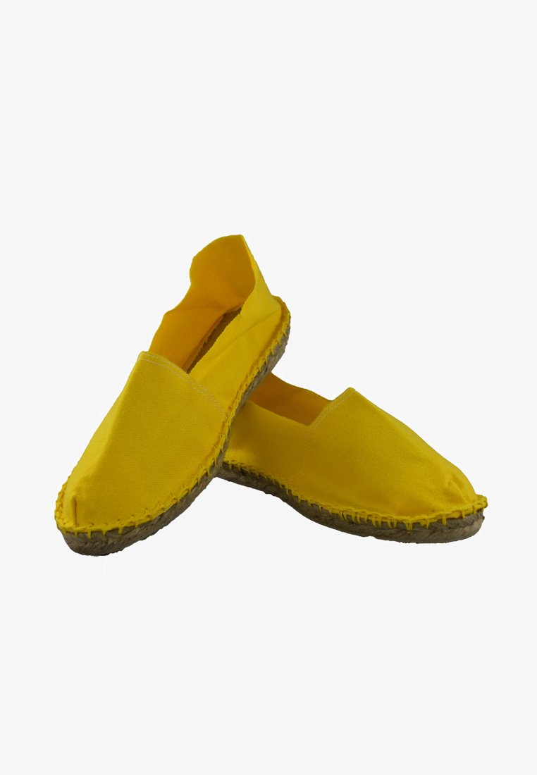 Espadrilles en toile jaune avec des inserts élastiques sur les côtés, semelles en jute et des détails visibles de couture à la main. Design simple à enfiler.