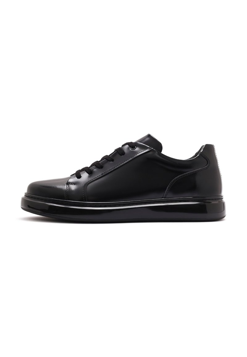 Black leather sneakers with a glossy finish, rounded toe, thick sole, and lace-up closure. Minimal stitching and a sleek silhouette.
