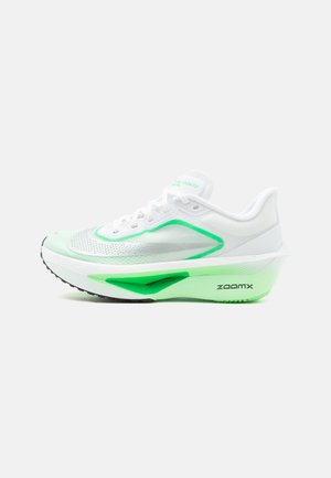 Weißer und grüner leichter Laufschuh mit dicker gepolsterter Sohle und schwarzer "ZoomX"-Markierung an der Seite, auf einfachem Hintergrund dargestellt.