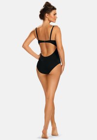 Czarny jednoczęściowy strój kąpielowy z wąskimi, regulowanymi ramiączkami i odkrytymi plecami. Gładka tkanina z dopasowaną sylwetką, minimalistyczny styl.