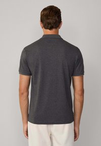 Polo shirt grigio antracite con colletto piatto, maniche corte e tessuto texture. La vista posteriore mostra un design pulito senza branding visibile.