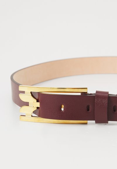 Curea din piele bordo cu o textură netedă, dotată cu o cataramă din metal de culoare aurie, cu un design minimalist și găuri ajustabile pentru dimensiune.