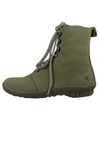 Oliwkowo-zielony but wykonany z zamszu, z okrągłym przodem, sznurowanym zapięciem i gumową podeszwą z wytłoczonym napisem. Smukły, minimalistyczny design.