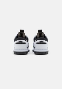 Black and white sneakers with a textured leather upper, padded collar, and rubber sole. Features pull tabs on the heel for easy wear.