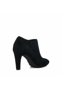 Bottes à talons hauts en suède noir, montant jusqu'à la cheville, avec un bout pointu et une surface lisse et texturée ; elles présentent une silhouette élégante et un talon effilé.
