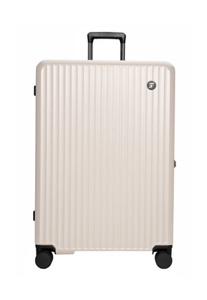 Hard-shell suitcase in light beige, featuring vertical grooves, a retractable black handle, and four black wheels for easy mobility.