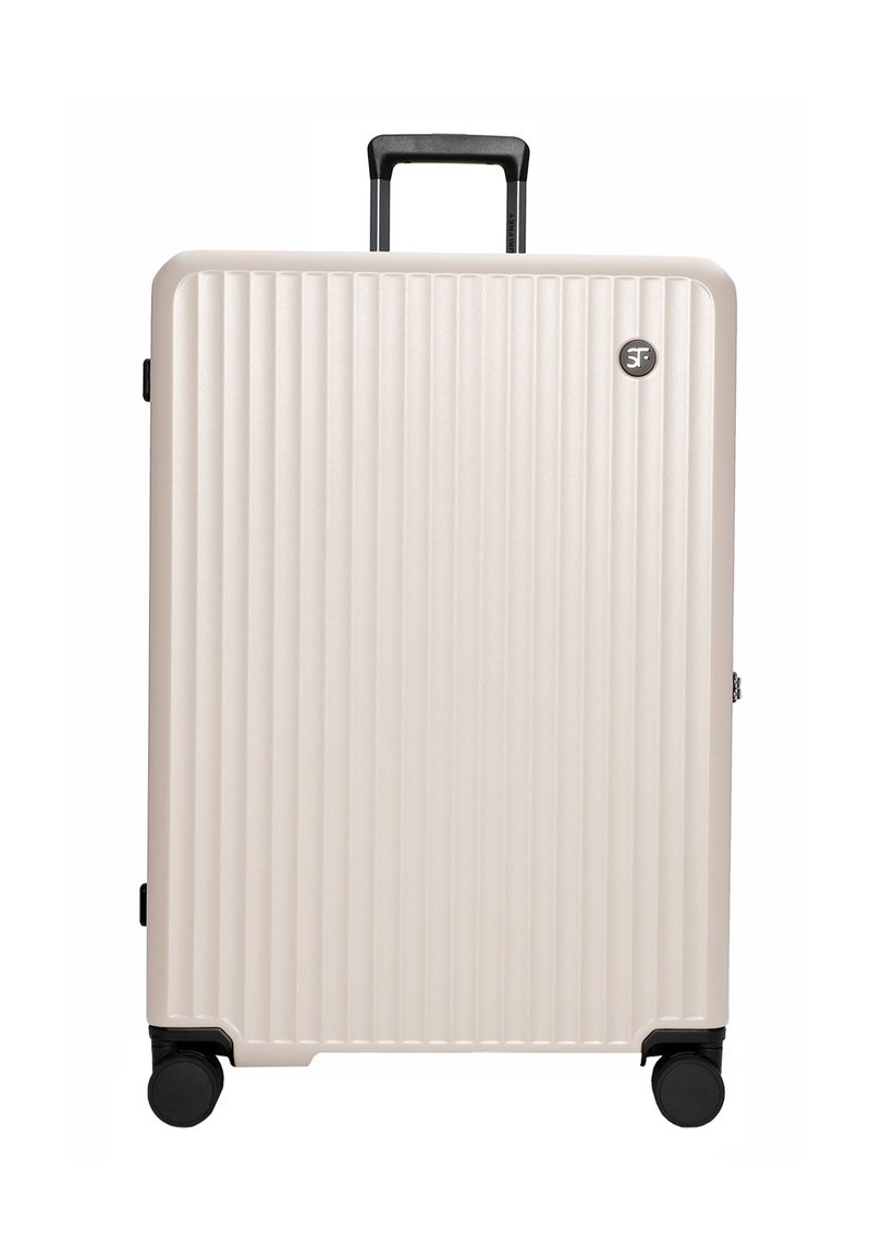 Hard-shell suitcase in light beige, featuring vertical grooves, a retractable black handle, and four black wheels for easy mobility.
