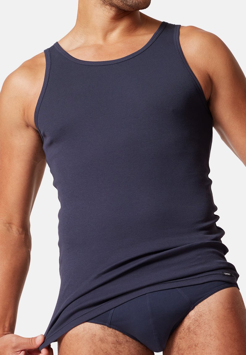 Granatowy top na ramiączkach wykonany z miękkiego materiału, z okrągłym dekoltem i szerokimi wycięciami na ramionach, charakteryzujący się dopasowanym krojem i minimalnymi detalami przeszycia.