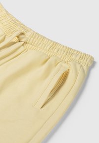 Lichtgele sweatpants van zacht katoen, met een elastische tailleband, trekkoord en zijzakken. Glad textiel, ontspannen pasvorm.