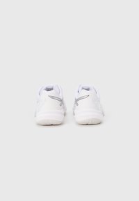 Ζευγάρι λευκά αθλητικά παπούτσια με ασημένιο λογότυπο, ορατά από πίσω, σε απλό λευκό φόντο.