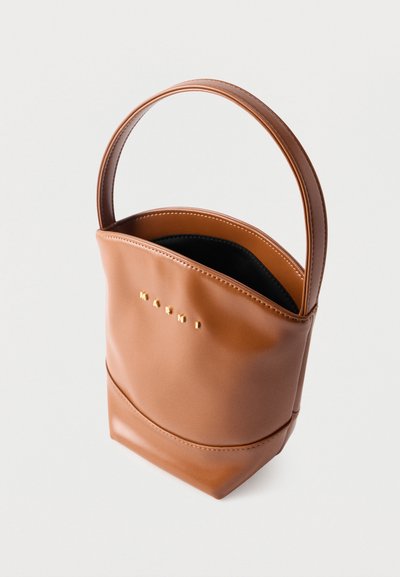 Καφέ δερμάτινη τσάντα τύπου κουβά με ένα λουρί και μικρά χρυσά γράμματα που σχηματίζουν τη λέξη "MARNI" στο μπροστινό μέρος, πάνω σε λευκό φόντο.