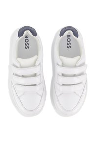 Witte sneakers met drie klittenbandsluitsingen, gewatteerde kraag en een marineblauwe accent op de hiel. Gladde leren bovenkant, met een gestructureerde binnenvoering.