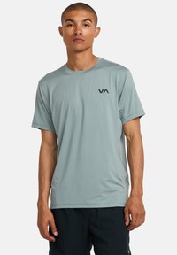 Camiseta atlética de manga corta de color verde claro, confeccionada con material transpirable, con cuello redondo y un pequeño logo negro en el pecho.