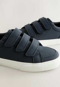 Marinero blauwe schoenen met drie verstelbare klittenbandsluitingen, glad synthetisch materiaal, witte rubberen zolen en textuurzolen voor grip.