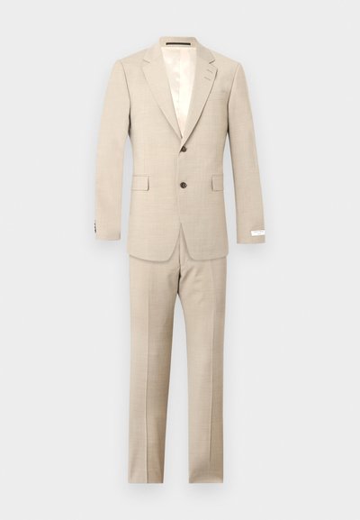 Ανδρικό κοστούμι σε μπεζ χρώμα με δύο κουμπιά, γιακά με σχισμή, τσέπες με καπάκι και αντίστοιχο παντελόνι, σε απλό ανοιχτό γκρι φόντο.