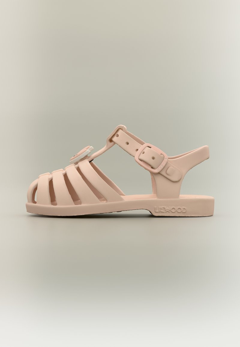 Sandale en caoutchouc rose pour tout-petit, taille enfant, avec bout fermé, bride de cheville ajustable et fleur décorative sur le dessus, vue de profil.