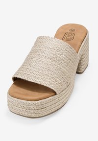 Sandalo platform beige con parte superiore in corda intrecciata, punta aperta e una soletta liscia color tan. Design con tacco chunky e dettagli in texture impilata.