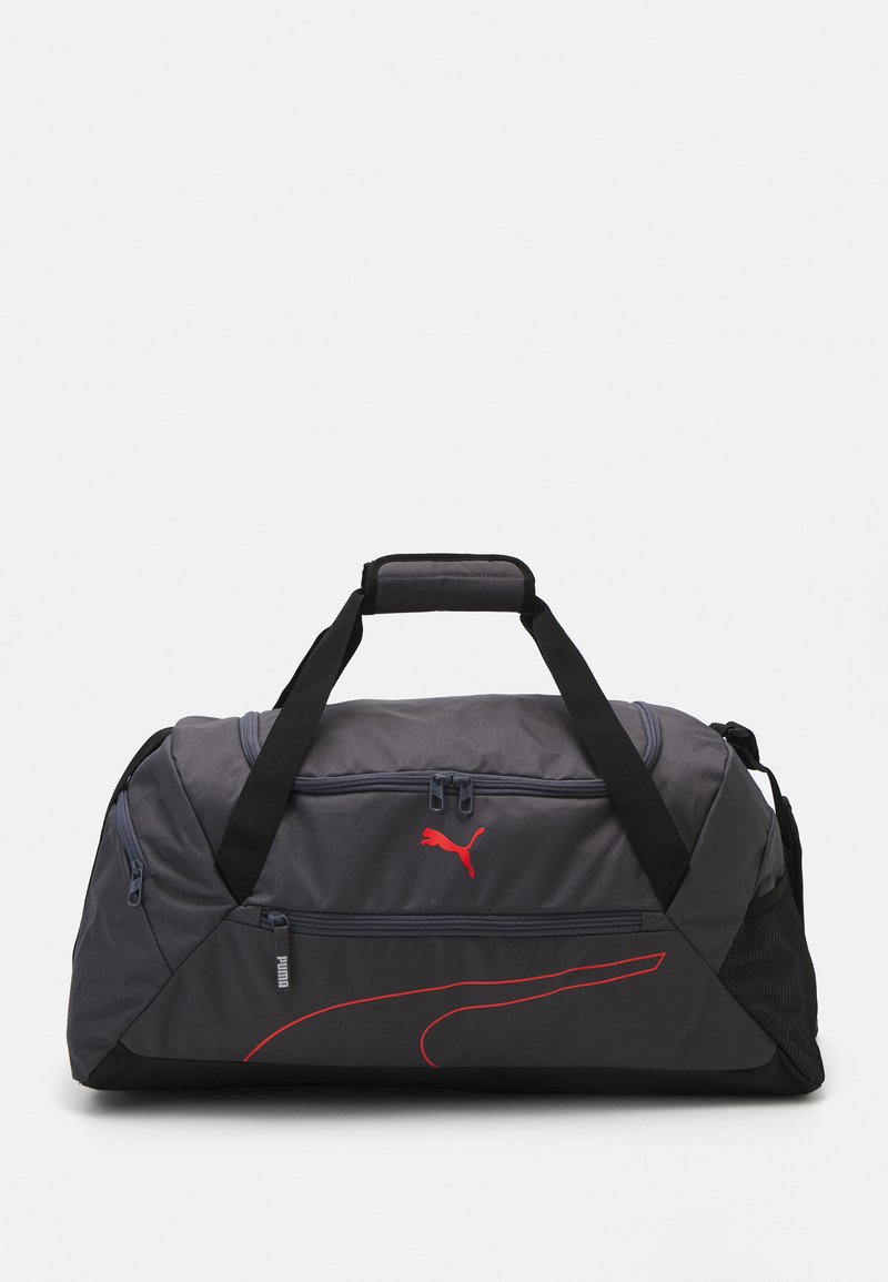 Bolsa de deporte gris hecha de un tejido duradero, con el logotipo rojo de PUMA, cremalleras y acentos en negro. Incluye un bolsillo de malla lateral y dos asas para llevar.
