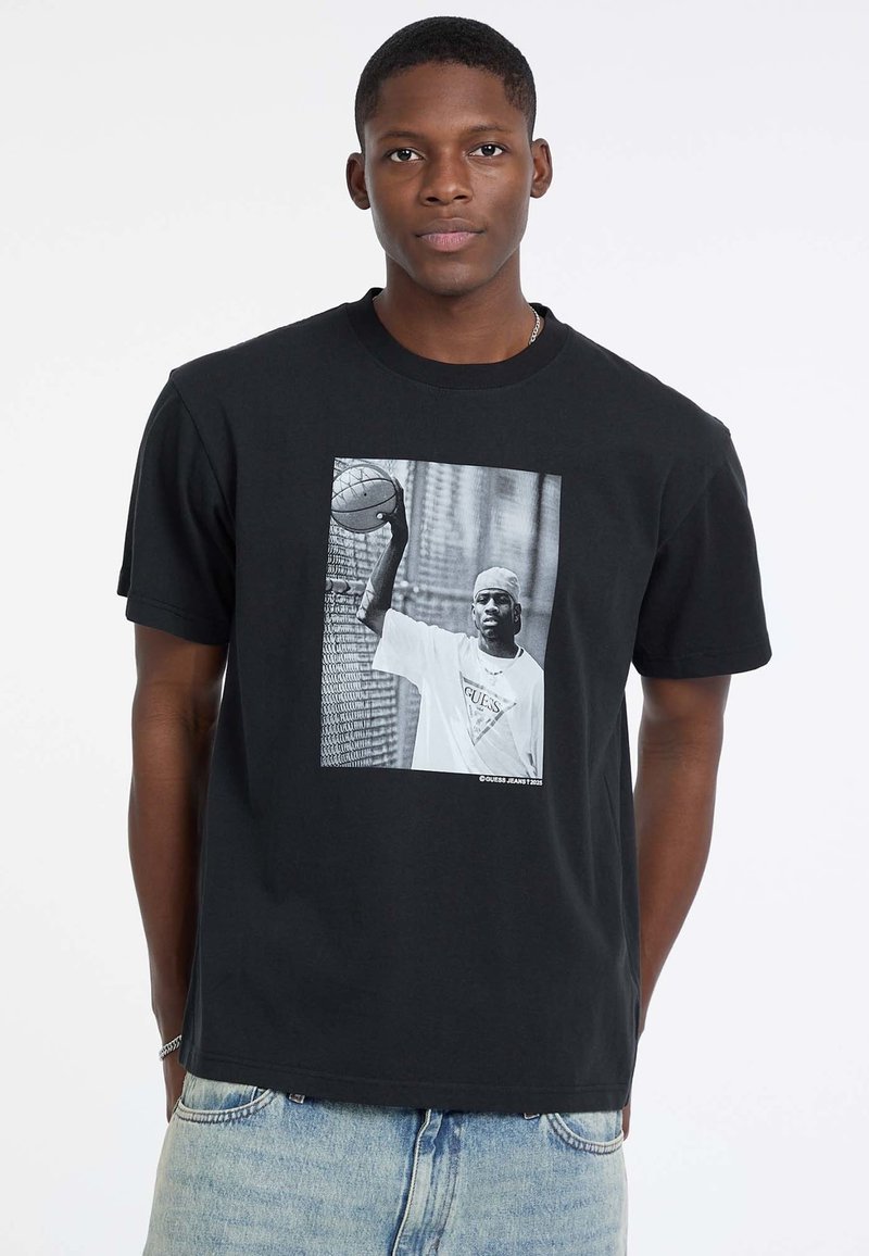 T-shirt en coton noir avec un graphique en façade d'un joueur de basketball. Conception à col rond avec des manches courtes et coupe décontractée.