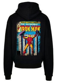 Čierna mikina s kapucňou s farebnou potlačou komiksu Iron Man na zadnej strane, ktorá zobrazuje žltého a červeného superhrdinu na textúrovanom pozadí.