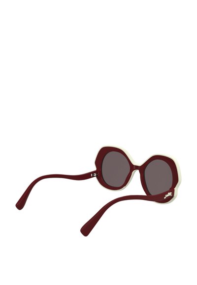 Occhiali da sole bordeaux con montatura ottagonale, dettagli bianchi e lenti scure. Presentano aste sottili e curve con un emblema decorativo.