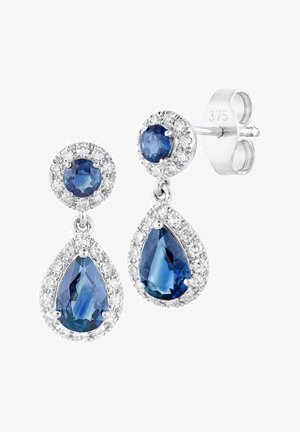 Srebrne kolczyki zdobią okrągłe i łezkowate niebieskie kamienie szlachetne otoczone małymi, przezroczystymi kryształkami. Posiadają zapięcie na sztyft, zapewniające pewne noszenie.