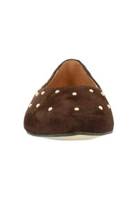 Bruine suède platte schoen met een ronde neus, versierd met gouden studs over de bovenkant. De binnenkant is beige en heeft een subtiel textuurpatroon.