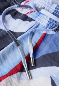 Korte broek met trekkoord, voorzien van een meerkleurig patroon in blauw, rood en grijs, van een gestructureerde stof en met metalen aglets aan de trekkoorden.