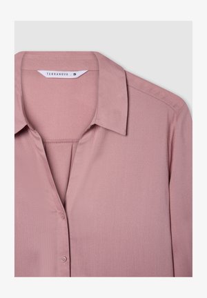 Blusa rosa chiaro, con colletto e chiusura a bottoni, presenta una texture di tessuto liscia e un design semplice, etichettata "Terranova" taglia S.