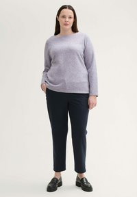 Lichtpaarse trui met lange mouwen en een losse pasvorm, gecombineerd met marineblauwe op maat gemaakte broek en zwarte instappers. Gladde textuur, eenvoudig ontwerp.