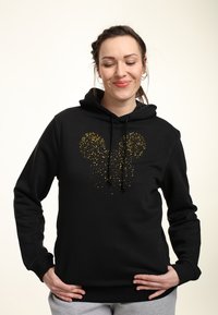 Felpa nera con un design del profilo di Mickey Mouse punteggiato d'oro al centro. Caratterizzata da un cappuccio con cordino e polsini a costine.