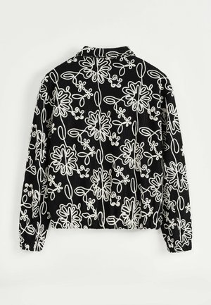 Veste noire à manches longues avec des motifs floraux abstraits blancs et des poignets élastiques, vue de dos sur fond blanc.