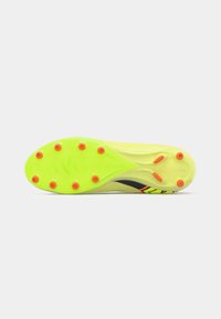 Crampon de fotbal cu o talpă galbenă strălucitoare și năsturei portocalii, cu un accent negru și roz pe lateral și o suprafață texturată.